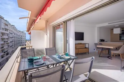 a dining room and living room with a table and chairs at Amazing Apartment With Private Terrace & Full Air Conditioning - Walk To The Beach, La Croisette! - Latour Maubourg 18 by Halldis in Cannes
