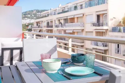 a table with plates and bowls on a balcony at Amazing Apartment With Private Terrace & Full Air Conditioning - Walk To The Beach, La Croisette! - Latour Maubourg 18 by Halldis in Cannes