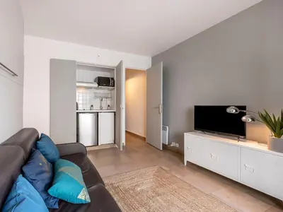 a living room with a couch and a flat screen tv at Apartment Le Marlyne 2-3 by Interhome in Cannes