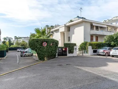 a large white building with a parking lot at Apartment Le Marlyne 2-3 by Interhome in Cannes