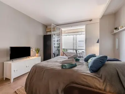 a bedroom with a large bed with blue pillows on it at Apartment Le Marlyne 2-3 by Interhome in Cannes
