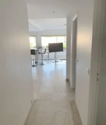 an empty room with a hallway with a desk and a television at Charming 2 room , 52 m2, very spacious, bright and near sea Martinez hotel in Cannes