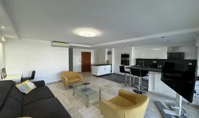 a living room with a couch and a kitchen at Charming 2 room , 52 m2, very spacious, bright and near sea Martinez hotel in Cannes