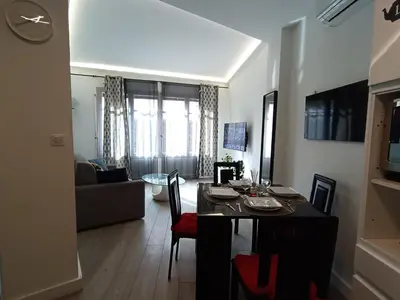 a living room with a dining table and a living room with a couch at Foras Urban Living à 2 pas du festival in Cannes