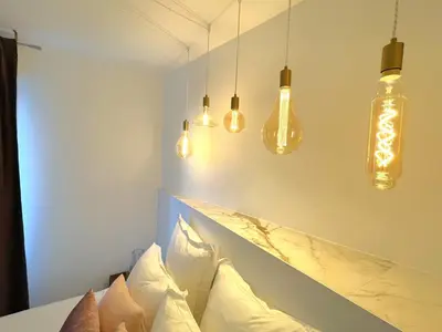 a room with several lights hanging over a bed at Alba DeLuxe - 3 Bedroom Pointe Croisette, by Welcome to Cannes in Cannes