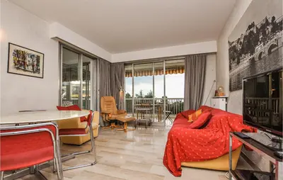 a living room with a bed and a table and a television at Beautiful Apartment In Cannes With Wifi in Cannes