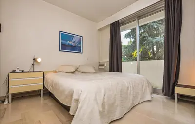 a bedroom with a bed and a large window at Beautiful Apartment In Cannes With Wifi in Cannes