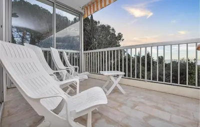 a group of white chairs on a balcony at Beautiful Apartment In Cannes With Wifi in Cannes