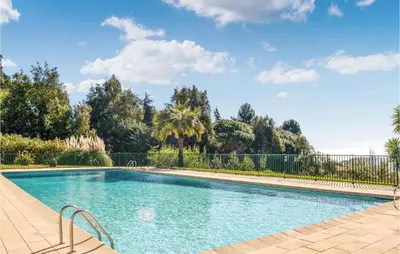 a swimming pool with a fence and trees at Beautiful Apartment In Cannes With Wifi in Cannes