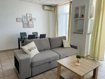 a living room with a couch and a table at Cannes : Agréable et lumineux appartement vue mer in Cannes
