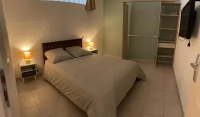 a bedroom with a bed and two night stands with lamps at Cannes : Agréable et lumineux appartement vue mer in Cannes