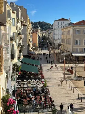 a group of people sitting at tables on a city street at Cannes : Agréable et lumineux appartement vue mer in Cannes