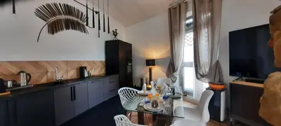 a kitchen with a table and chairs and a television at Appartement Loft ATYPIQUE et ravissant de 60 m2 Nouveau in Cannes