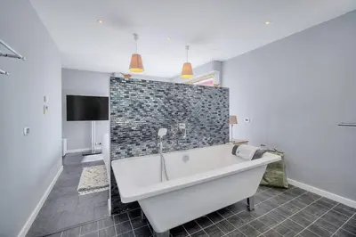 a bathroom with a bath tub and a tv at IMMOGROOM -Rooftop 150m2 -Terrace 150m2 -Parking -Wifi - AC in Cannes
