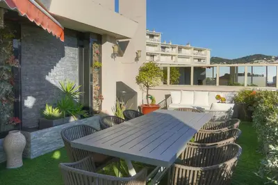 a wooden table and chairs on a patio with a table at IMMOGROOM -Rooftop 150m2 -Terrace 150m2 -Parking -Wifi - AC in Cannes