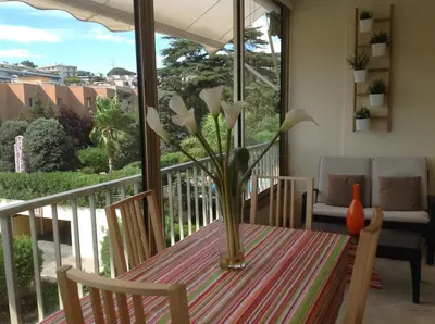 a vase of flowers sitting on a table on a balcony at Spacious studio in the center of Cannes nice terrace easy walk to the Croisette and Palais - 1923 in Cannes