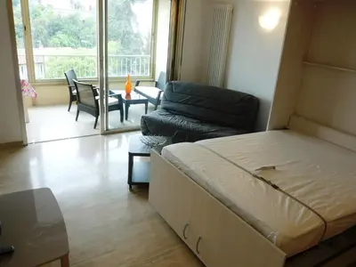 a bedroom with a bed and a living room with a couch at Spacious studio in the center of Cannes nice terrace easy walk to the Croisette and Palais - 1923 in Cannes