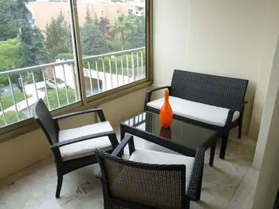 a room with chairs and a table with a vase on it at Spacious studio in the center of Cannes nice terrace easy walk to the Croisette and Palais - 1923 in Cannes