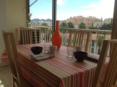 a table with a vase and glasses on a balcony at Spacious studio in the center of Cannes nice terrace easy walk to the Croisette and Palais - 1923 in Cannes