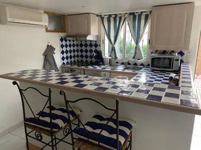 a kitchen with a counter and two chairs at a counter top at STUDIO classé 3 étoiles 10 mn Cannes in Le Cannet