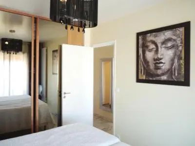 a bedroom with a portrait of a man on the wall at Stylish one bedroom apartment in Central Cannes just off the Croisette and near beaches - 680 in Cannes