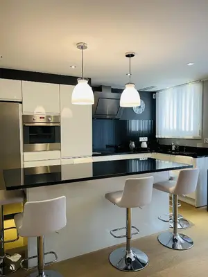 a kitchen with black and white cabinets and bar stools at Magnifique Modern appartement avec terrasse FERN12 in Cannes
