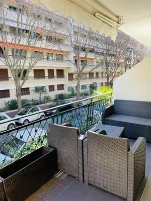 a balcony with chairs and a view of a building at Magnifique Modern appartement avec terrasse FERN12 in Cannes