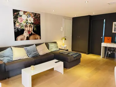 a living room with a couch and a painting on the wall at Magnifique Modern appartement avec terrasse FERN12 in Cannes