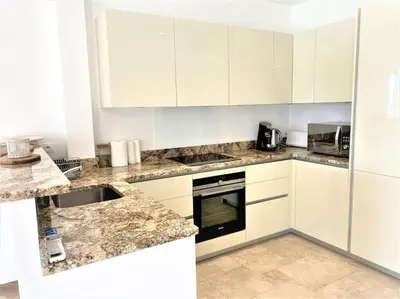 a kitchen with white cabinets and marble counter tops at Viva Riviera Résidence Les Dunes 90 Croisette in Cannes