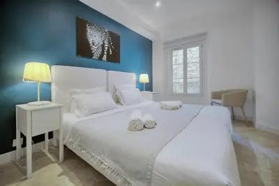 a bedroom with a large white bed with two towels on it at IMMOGROOM- Apartment 70m2 - Renovated - Wifi - AC - Close to everything in Cannes