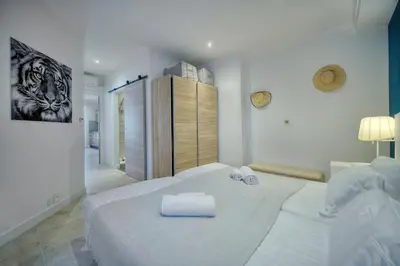 a white bedroom with two beds with towels on them at IMMOGROOM- Apartment 70m2 - Renovated - Wifi - AC - Close to everything in Cannes