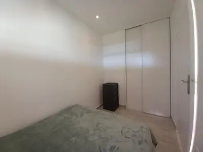 a white bedroom with a bed and a closet at Le Trident B in Cannes