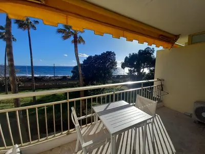 a balcony with a table and chairs and the ocean at Le Trident B in Cannes