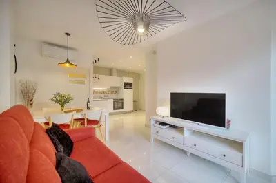 a living room with a red couch and a flat screen tv at Elégant 2 pièces TERRASSE, CARLTON MARTINEZ- Proche CROISETTE A1B238 in Cannes