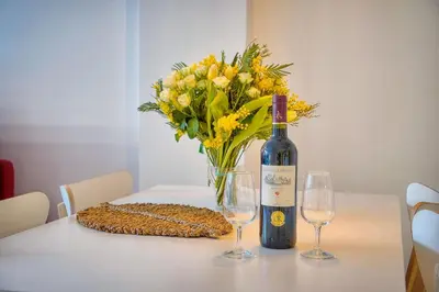 a bottle of wine and two glasses on a table with flowers at Elégant 2 pièces TERRASSE, CARLTON MARTINEZ- Proche CROISETTE A1B238 in Cannes