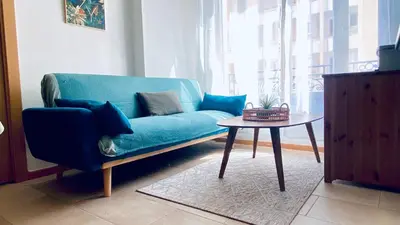a blue couch in a living room with a table at Appartement Cannes centre ville pour congrès ou vacances à 5 min de la Croisette, plage in Cannes