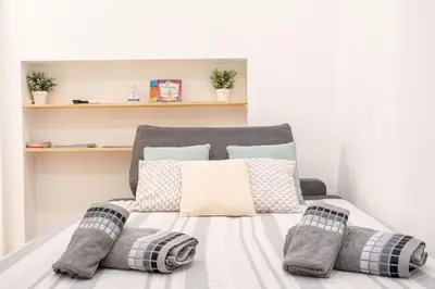 a bed with pillows on it in a room at Centre Cannes - 5 Mins Des Plages Et Du Palais ! - Joseph Méro in Cannes