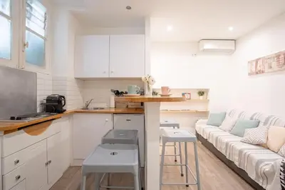 a kitchen and living room with a couch and a table at Centre Cannes - 5 Mins Des Plages Et Du Palais ! - Joseph Méro in Cannes
