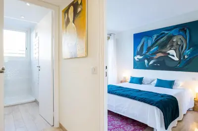 a bedroom with a bed and a painting on the wall at 2-Br in high Residential Property in Cannes