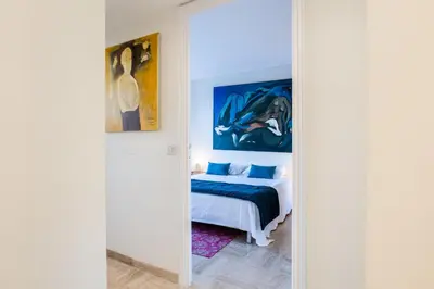 a bedroom with a bed and a painting on the wall at 2-Br in high Residential Property in Cannes