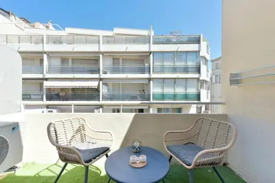 two chairs and a table on a balcony with a building at 1-Br apartment in the heart of Cannes in Cannes