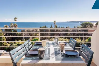 a dining table with a view of the ocean at Apartment With Panoramic Sea View, Walk To The Beach - Maréchal Juin by Halldis in Cannes