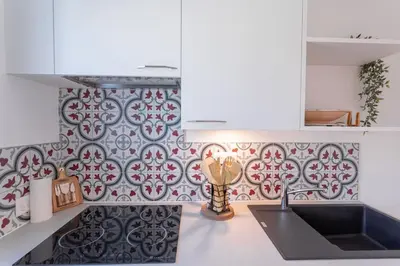 a kitchen with a black and white patterned wall at Apartment With Panoramic Sea View, Walk To The Beach - Maréchal Juin by Halldis in Cannes