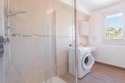 a bathroom with a washing machine and a shower at Apartment With Panoramic Sea View, Walk To The Beach - Maréchal Juin by Halldis in Cannes
