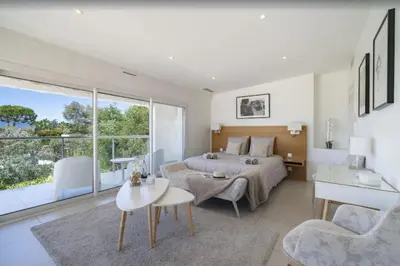 a bedroom with a bed and a table and a couch at FRGK Contemporary Luxury Villa Panoramic Sea View, Pool & Ultra-Fast Wi-Fi in Cannes