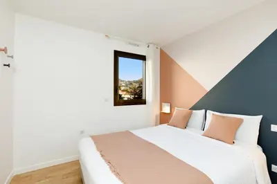 a bedroom with a bed and a window at Citybeach SOHA- Rue d'Antibes - 2 BdR 2 BthR 1 toil - Clim Terrace Parking Elevator in Cannes