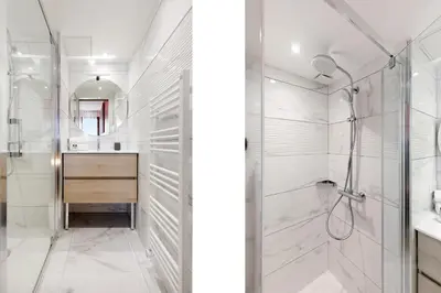 a white bathroom with a shower and a sink at Citybeach SOHA- Rue d'Antibes - 2 BdR 2 BthR 1 toil - Clim Terrace Parking Elevator in Cannes