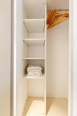 a closet with white shelves and a towel at Citybeach SOHA- Rue d'Antibes - 2 BdR 2 BthR 1 toil - Clim Terrace Parking Elevator in Cannes