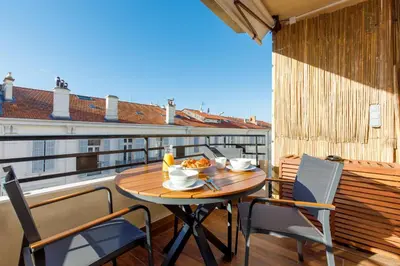 a table on a balcony with a bowl of food on it at Citybeach SOHA- Rue d'Antibes - 2 BdR 2 BthR 1 toil - Clim Terrace Parking Elevator in Cannes