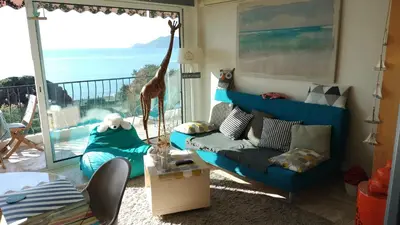 a living room with a giraffe standing on a balcony at Appartement vue mer panoramique, plage 150M, terrasse, parking privé, clim in Cannes